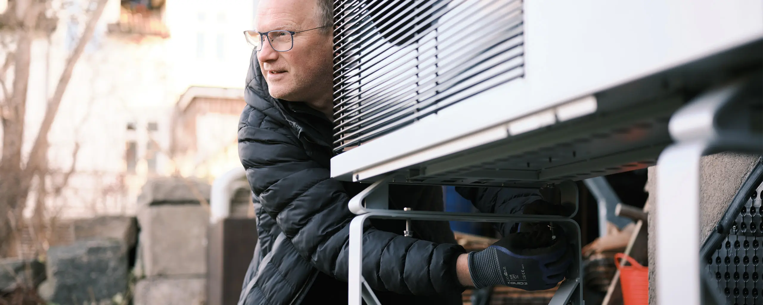 Man installing an outdoor unit heat pump.