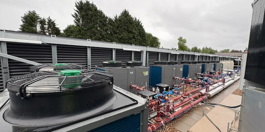 Several commercial heat pumps connected and placed on hotel buildings roof.